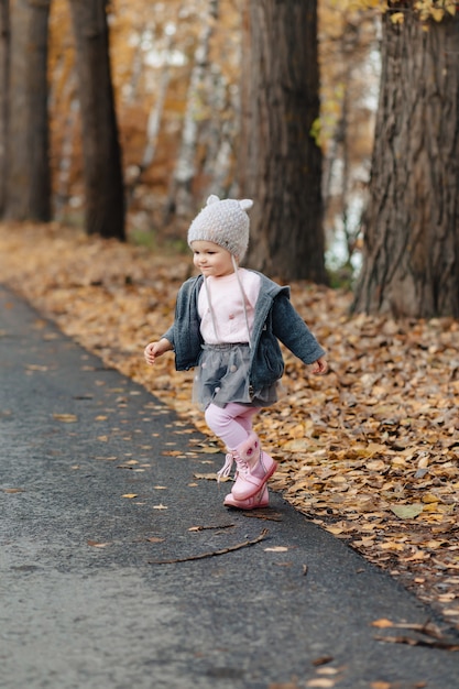 Petit bébé marche au parc, parmi les arbres jaunes à l&#39;automne