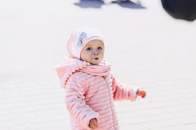 Petit bébé mignon marche sur la place avec des oiseaux