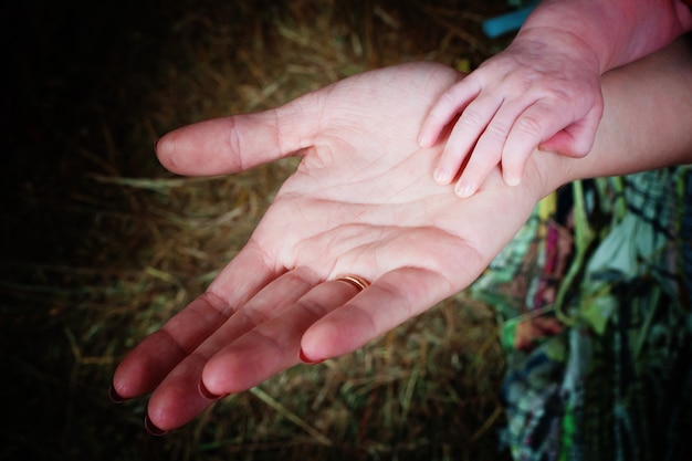 Petit bébé nouveau-né tenant la main de la mère