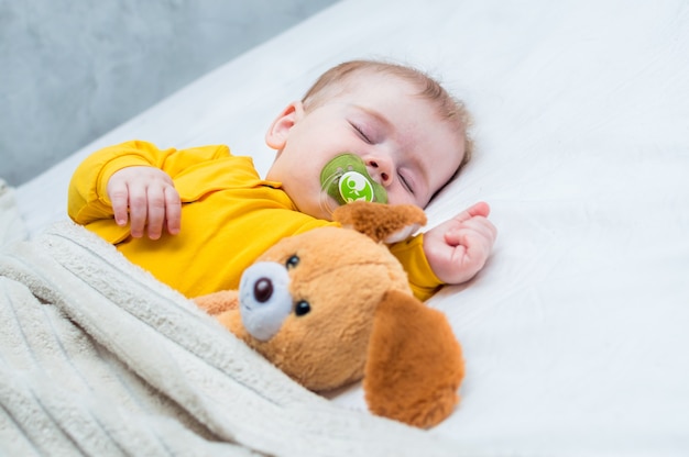 Petit bébé qui dort avec un jouet