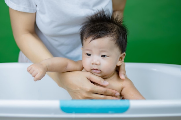 Petit bébé se baignant sur les mains des mères