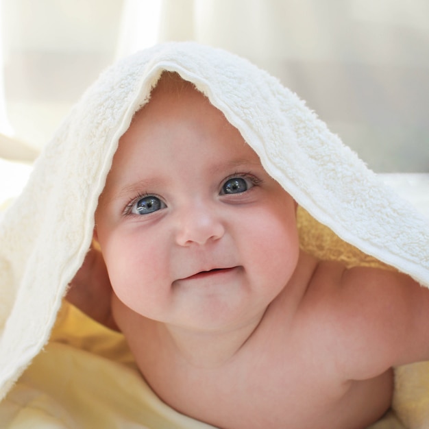 Un petit bébé sous une serviette blanche