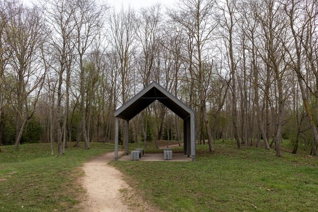 Un petit belvédère dans un parc arboré et un chemin menant à gauche.