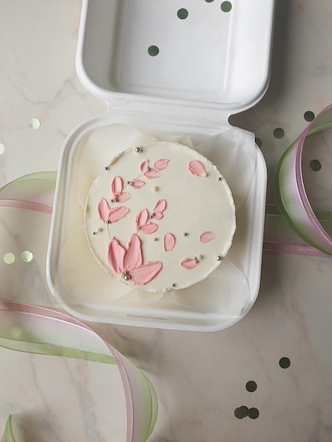 Petit bento blanc avec fleurs roses dessinées