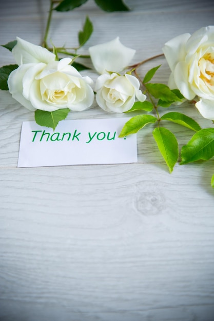 petit bouquet de belles roses blanches d'été sur une table en bois