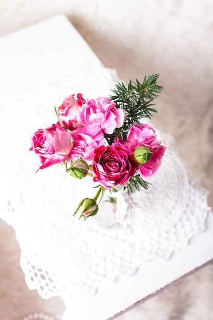 Petit bouquet douillet dans une bouteille en verre sur un napperon au crochet. Style vintage