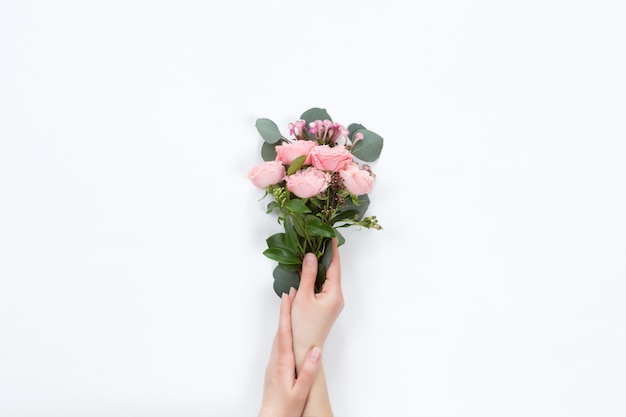 Petit bouquet de roses roses du bush dans la main d'une femme