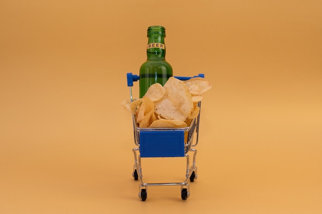 Photo petit caddie avec chips et une bouteille de bière