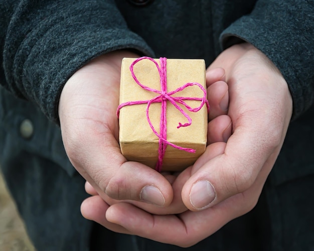 un petit cadeau dans la main d'un homme, mise au point sélective.