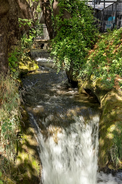 Photo petit canal dans le parc de la ville d'edessa macédoine centrale grèce avec de l'eau qui coule rapidement