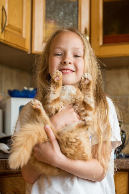 Petit chaton domestique persan mignon dans la main de la fille. Chat et enfant à la maison