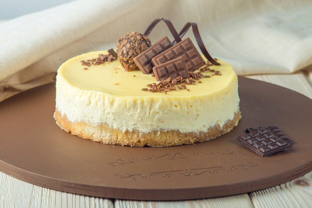 Petit cheesecake rond à la vanille décoré de chocolat et de truffes