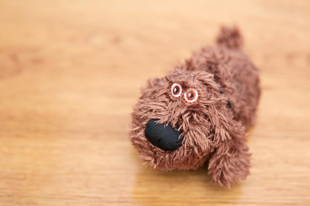 Petit chien en peluche sur une table en bois, flou