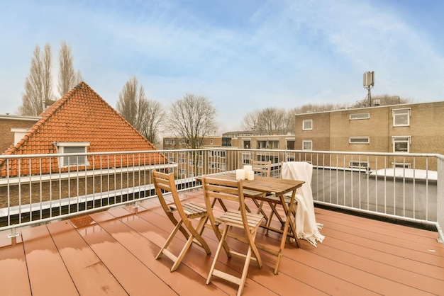 Un petit coin salon sur le toit avec des meubles en bois et un sol avec vue sur la ville