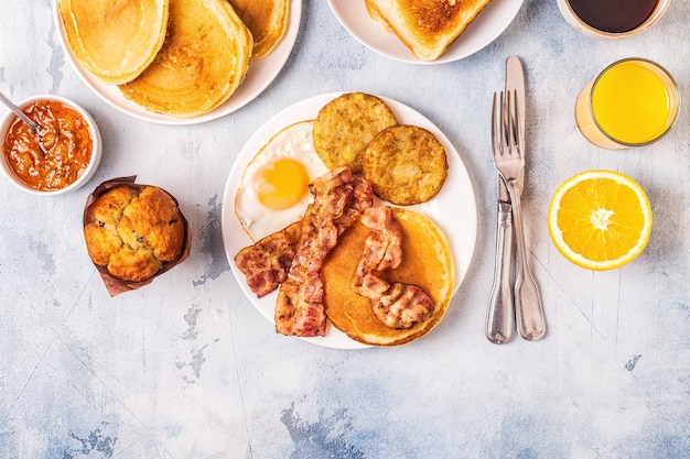 Petit-déjeuner américain complet sain avec des œufs de crêpes au bacon et Latkes, vue de dessus.