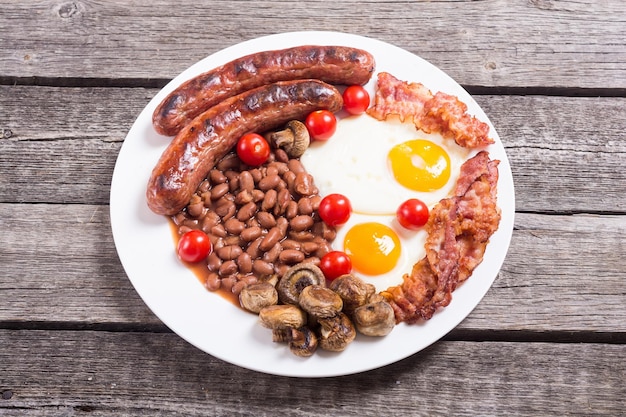 Petit déjeuner anglais avec bacon, saucisses, œufs, tomates, champignons et haricots.