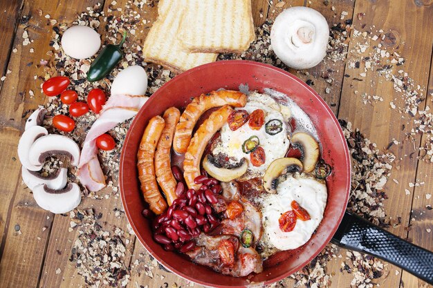 Photo petit déjeuner anglais complet dans une poêle à frire à fond en bois