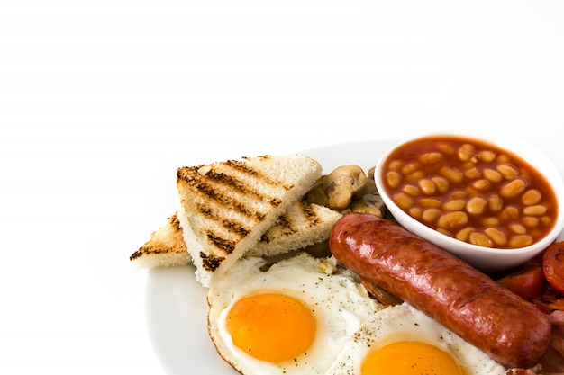 Petit-déjeuner anglais complet traditionnel avec des œufs au plat, des saucisses, des haricots, des champignons, des tomates grillées et du bacon sur isolé sur une surface blanche