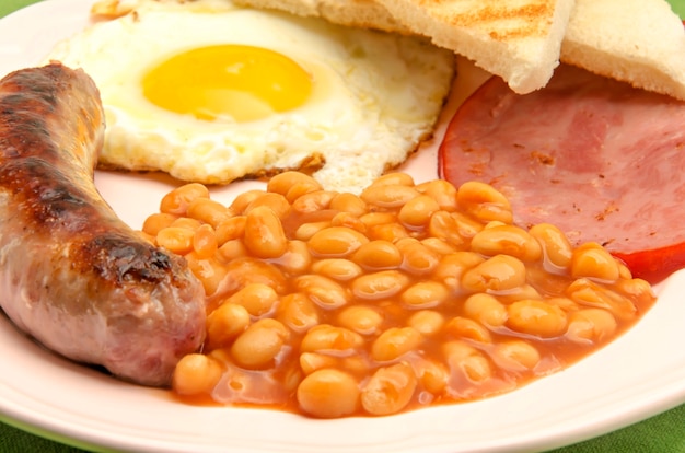 Petit-déjeuner anglais avec des haricots, des saucisses et des œufs au plat