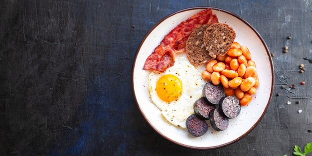 Petit-déjeuner anglais œuf frit boudin noir céréales pain de céréales boudin oeufs brouillés sur la table