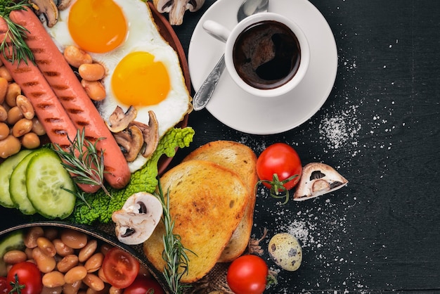 Petit-déjeuner anglais Oeufs frits saucisses bacon haricots toasts tomates tasse à café sur table en pierre vue de dessus avec espace pour votre texte