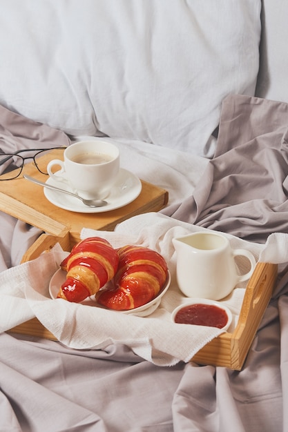 Petit déjeuner au lit, café à la crème, croissants en confiture