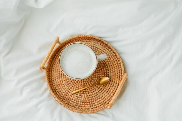 Petit déjeuner au lit, cappuccino, plateau en osier, décoration intérieure