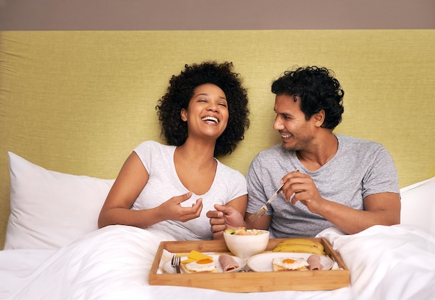 Petit déjeuner au lit Un joli couple partageant le petit déjeuner au lit