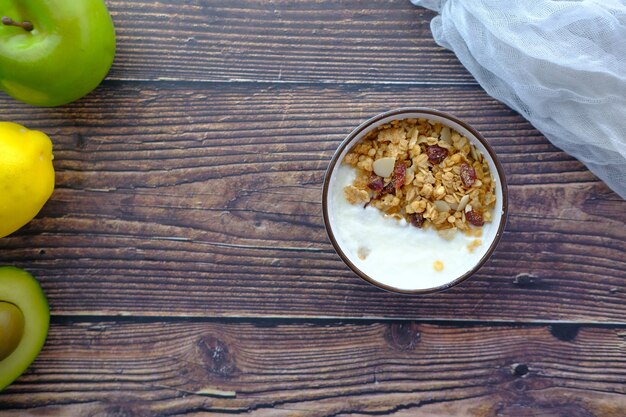 Petit-déjeuner aux céréales de yaourt dans un bol sur une surface en bois