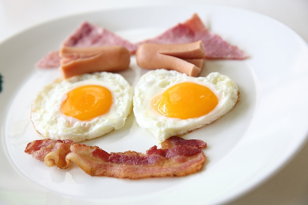 Petit déjeuner avec bacon, oeuf au plat et jus d'orange