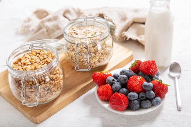 Petit-déjeuner avec baies fraîches granola et bouteille de lait