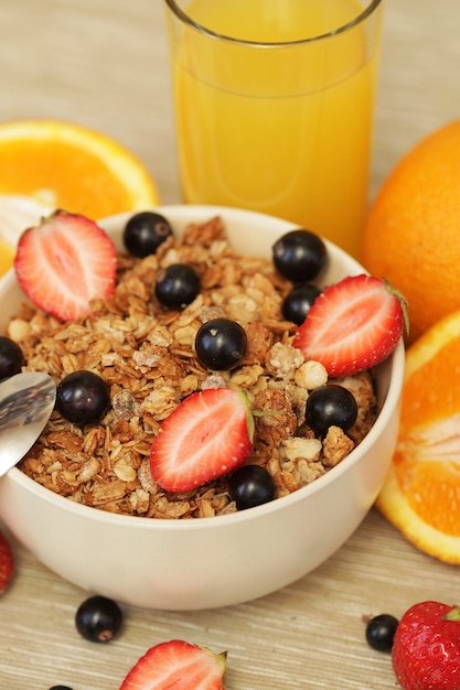 Petit déjeuner avec baies, muesli et jus d'orange