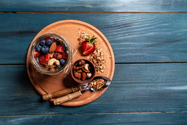 Petit déjeuner à base de yaourt naturel frais avec granola maison et fraise aux bleuets