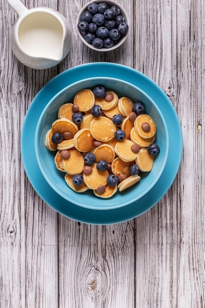 Petit-déjeuner branché avec mini crêpes, myrtilles et pépites de chocolat