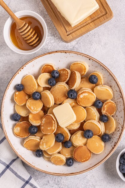 Petit-déjeuner branché avec mini crêpes et myrtilles, vue du dessus.