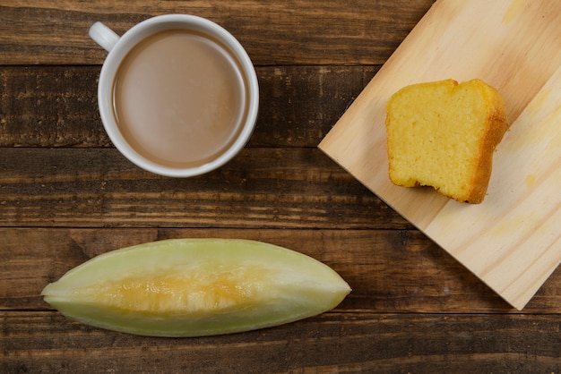 Petit-déjeuner brésilien avec café au lait, gâteau de maïs et pastèque.