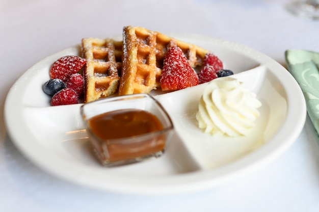 petit déjeuner ou brunch au restaurant. assiette blanche avec de délicieuses gaufres viennoises. mise au point sélective