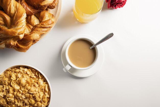 Petit-déjeuner avec café, viennoiseries, jus de fruits et céréales