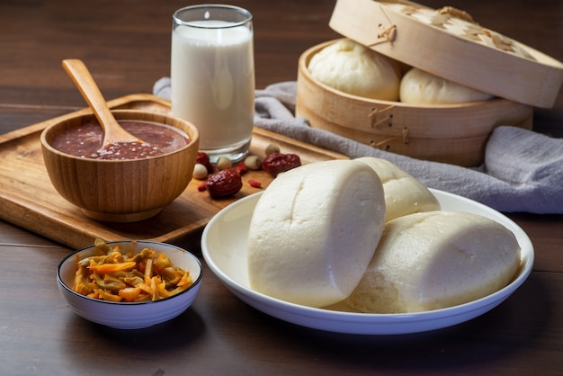 Photo petit-déjeuner chinois. les petits pains cuits à la vapeur et le porridge sont sur la table