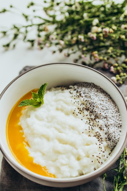 Petit-déjeuner composé de graines de chia et de purée de mangue servi dans une assiette en céramique