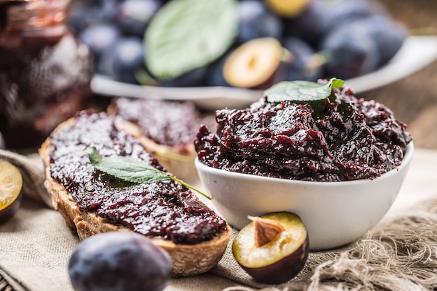 Petit-déjeuner composé de pain à la confiture de prunes maison et de prunes mûres fraîches.