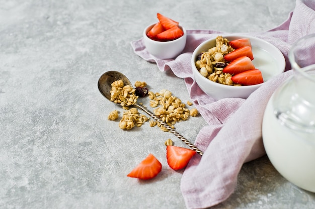 Le petit-déjeuner comprend du granola bio fait maison dans un bol de fraises et de yaourt.