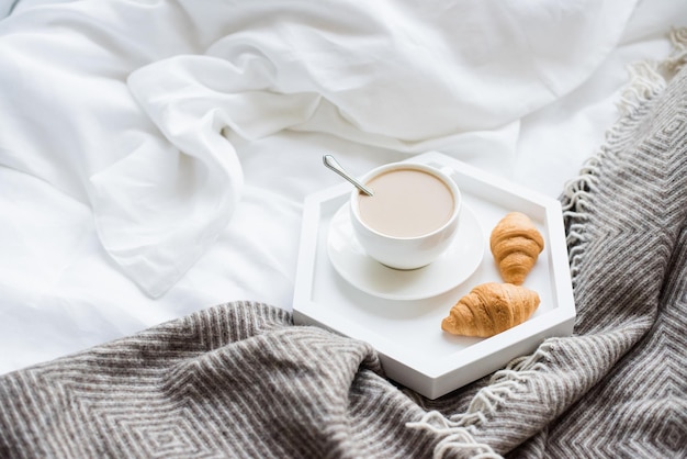 Petit déjeuner confortable au lit tasse de café et croissants