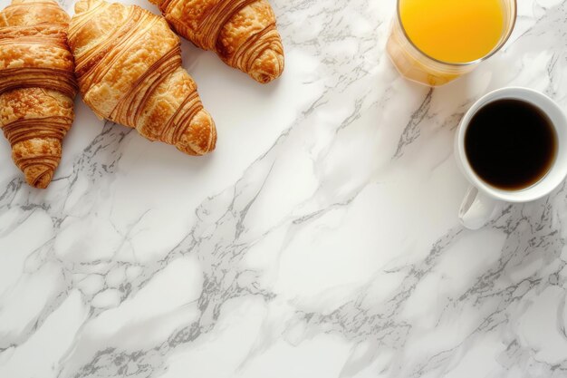 Petit déjeuner continental avec des croissants, du jus d'orange et une tasse de café sur un fond en marbre blanc avec une vue supérieure de l'espace de copie