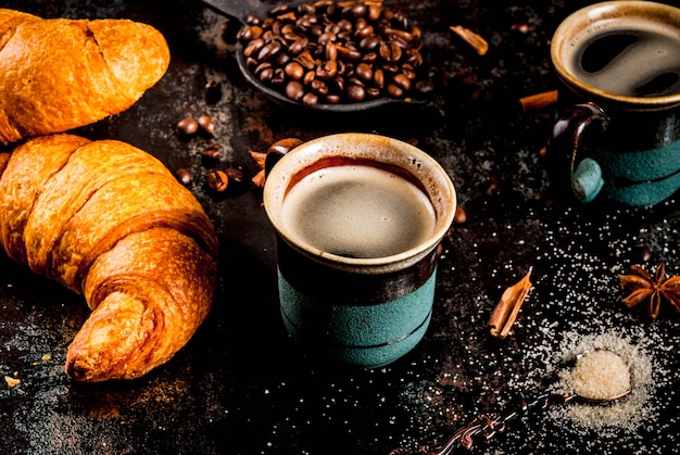 Petit déjeuner continental fait maison, café aux épices, sucre de canne, croissants. confiture sur une table en métal rouillé noir, copyspace