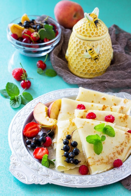 Petit-déjeuner crêpes au miel et baies fraîches de groseilles fraises nectarines