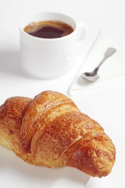 Petit déjeuner avec croissant et café sur fond blanc