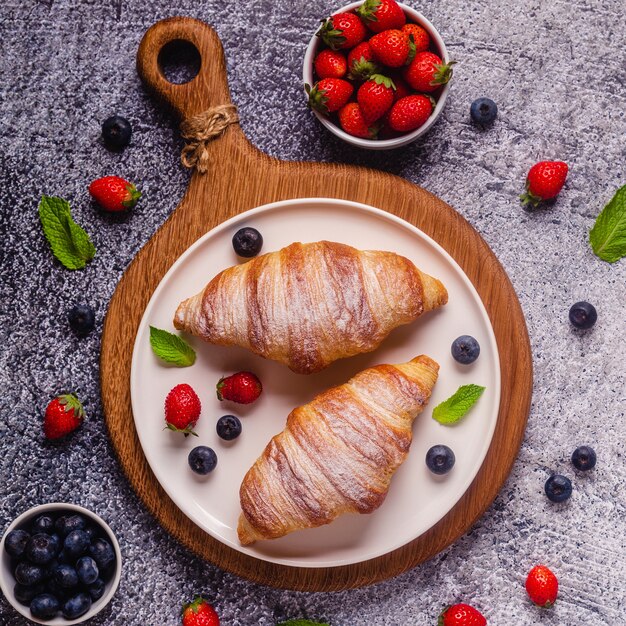 Petit déjeuner avec croissants et fruits frais, vue de dessus.