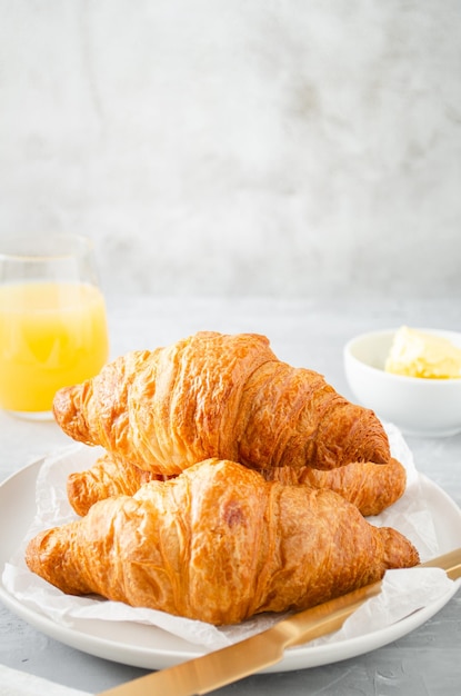 Petit déjeuner avec croissants et jus d'orange.