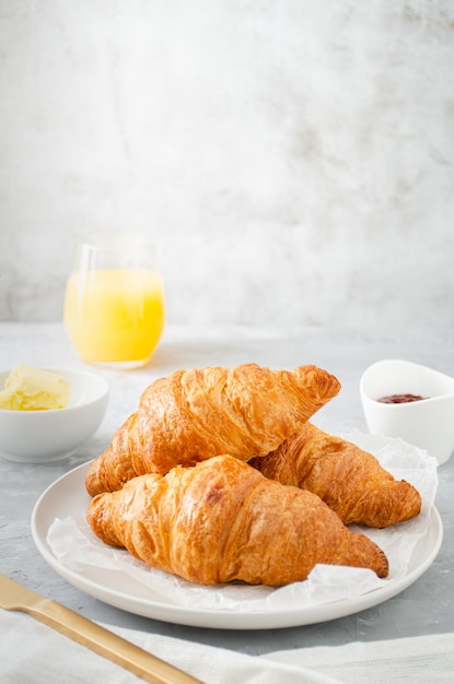 Petit déjeuner avec croissants et jus d'orange.